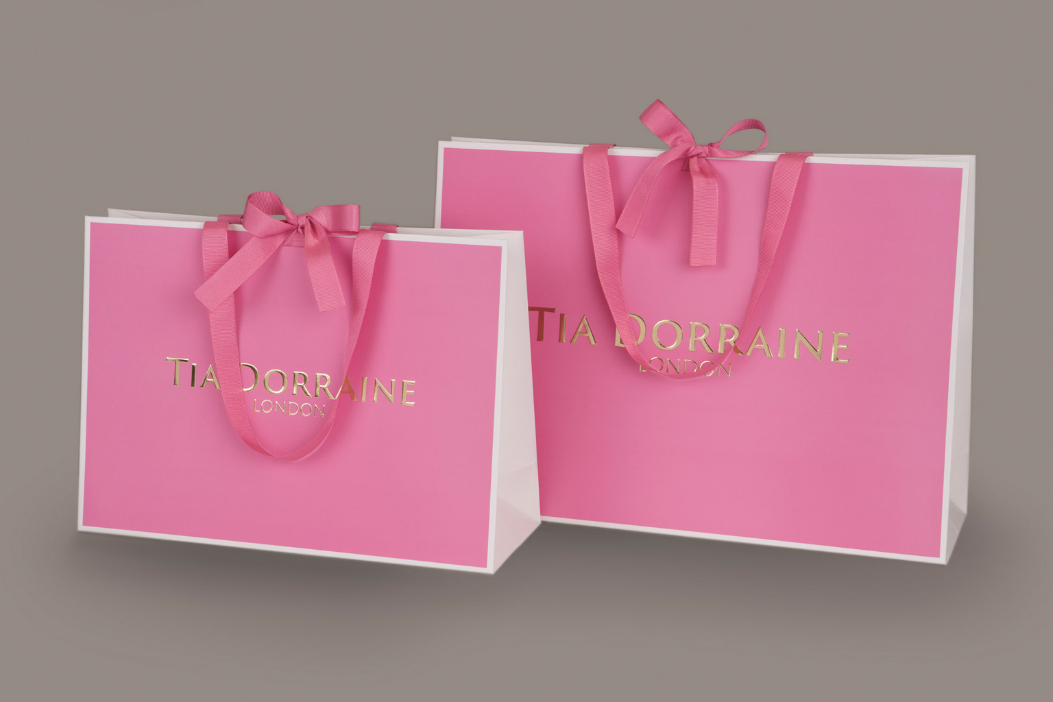 Premium paper bags with foil embossed logo and ribbon ties, manufactured in Europe